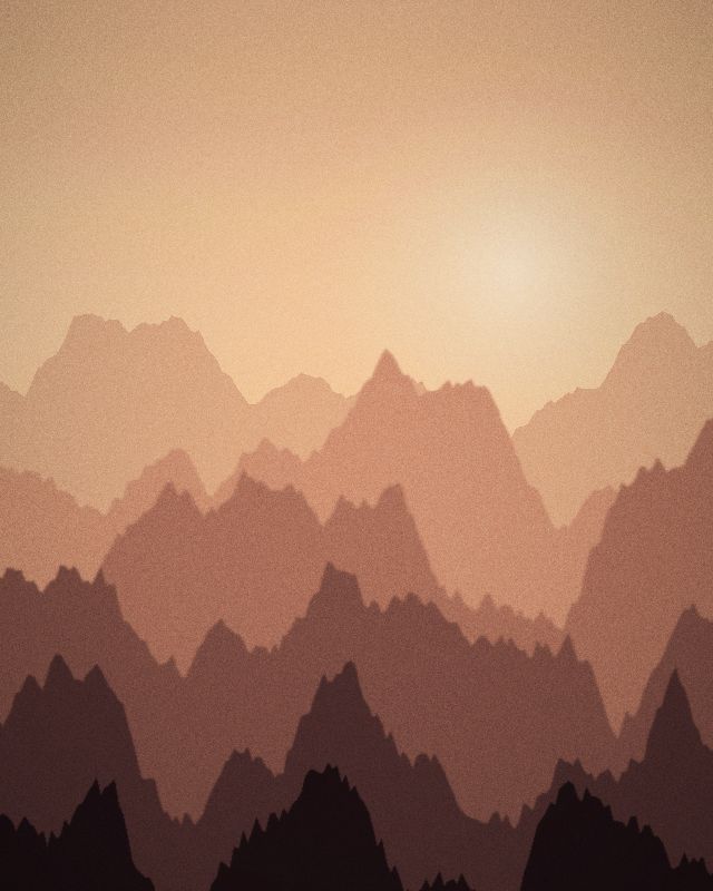 Layered mountain ridges in warm evening haze